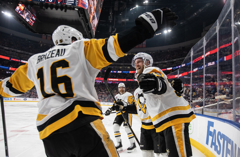 Pittsburgh Penguins' Justin Brazeau (16), Anthony Mantha (39) and Brett Kulak (77) celebrate after a goal against the Edmonton Oilers during first-period NHL hockey game action in Edmonton, Alberta, Thursday, Jan. 22, 2026. (Jason Franson/The Canadian Press via AP)
