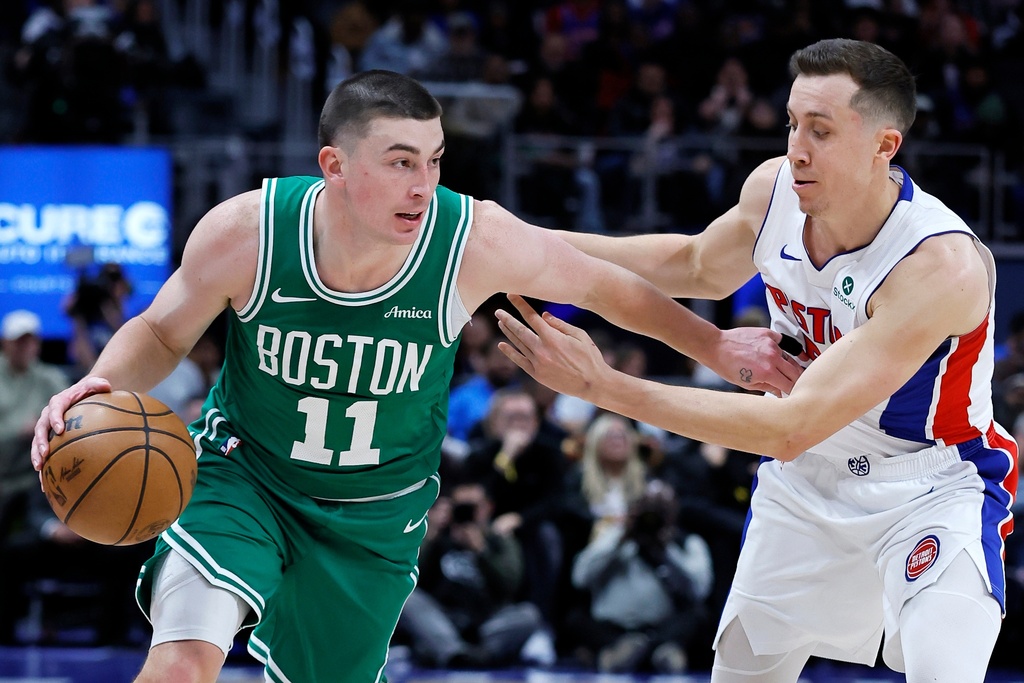 Boston Celtics guard Payton Pritchard (11) drives against Detroit Pistons forward Duncan Robinson during the first half of an NBA basketball game Monday, Jan. 19, 2026, in Detroit. (AP Photo/Duane Burleson)