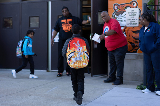 FILE - Students are guided inside as they arrive for school at Nash Elementary School, Friday, Sept. 5, 2025, in Chicago. (AP Photo/Carolyn Kaster, File) FILE - Students are guided inside as they arrive for school at Nash Elementary School, Friday, Sept. 5, 2025, in Chicago. (AP Photo/Carolyn Kaster, File)