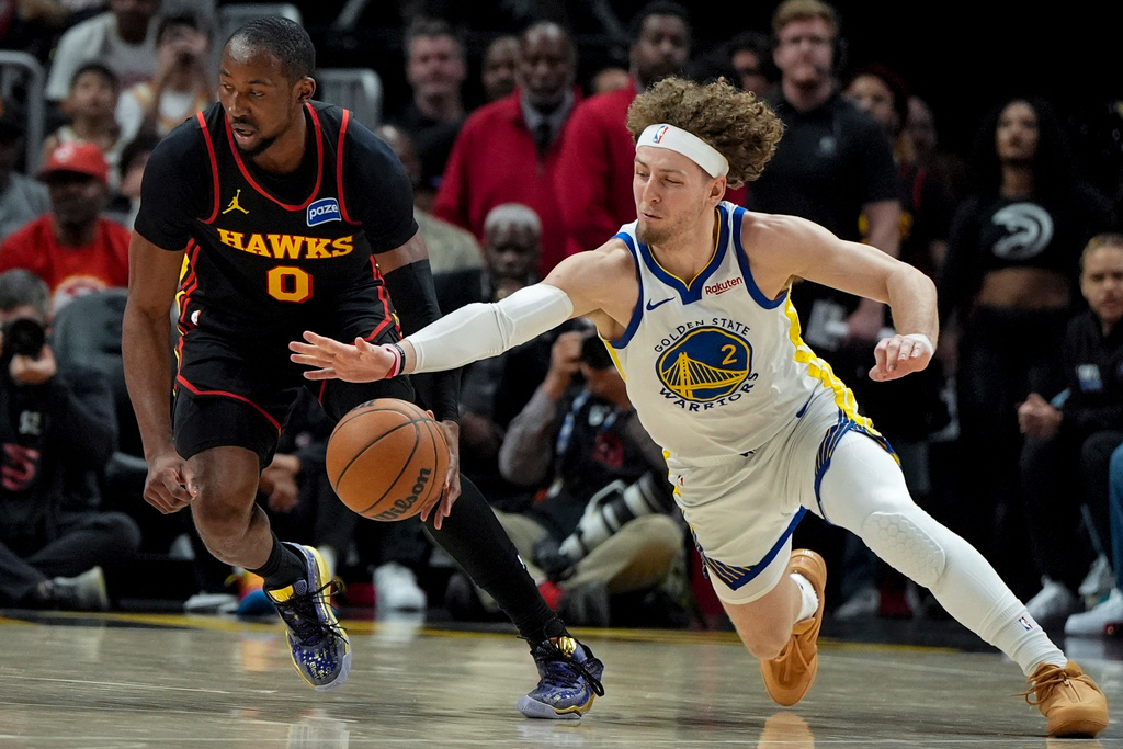 Golden State Warriors guard Brandin Podziemski (2) chases a loose ball with Atlanta Hawks forward Jonathan Kuminga (0) during the first half of an NBA basketball game, Saturday, March 21, 2026, in Atlanta. (AP Photo/Mike Stewart)