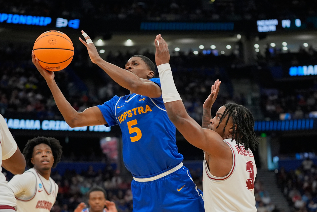 Hofstra guard Cruz Davis (5) shoots as he gets past Alabama guard Latrell Wrightsell (3) during the second half in the first round of the NCAA college basketball tournament, Friday, March 20, 2026, in Tampa, Fla. (AP Photo/John Raoux)
