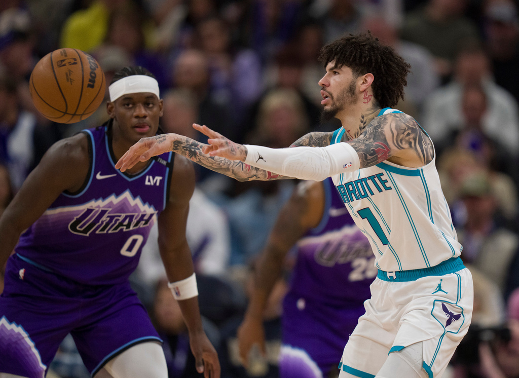 Charlotte Hornets guard LaMelo Ball (1) passes the ball as he is defended by Utah Jazz forward Taylor Hendricks (0) during the first half of an NBA basketball game, Saturday, Jan. 10, 2026, in Salt Lake City. (AP Photo/Bethany Baker)