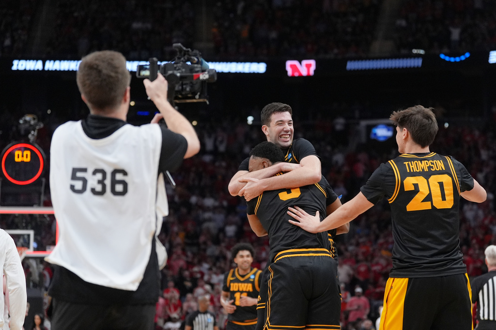 Iowa forwards Alvaro Folgueiras, rear, Cam Manyawu (3) and forward Trey Thompson (20) celebrate after defeating Nebraska in the Sweet 16 of the NCAA college basketball tournament Thursday, March 26, 2026, in Houston. (AP Photo/Eric Gay)