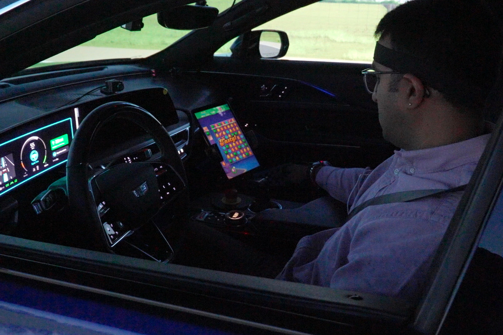 In this image from video, General Motors senior researcher Akilesh Rajavenkatanarayanan plays Candy Crush on a tablet mounted in a Cadillac Lyriq while it is in "eyes off" mode during a simulated drive at the automaker's Global Technical Center Friday, Sept. 18, 2026, in Warren, Mich. (AP Photo/Mike Householder)