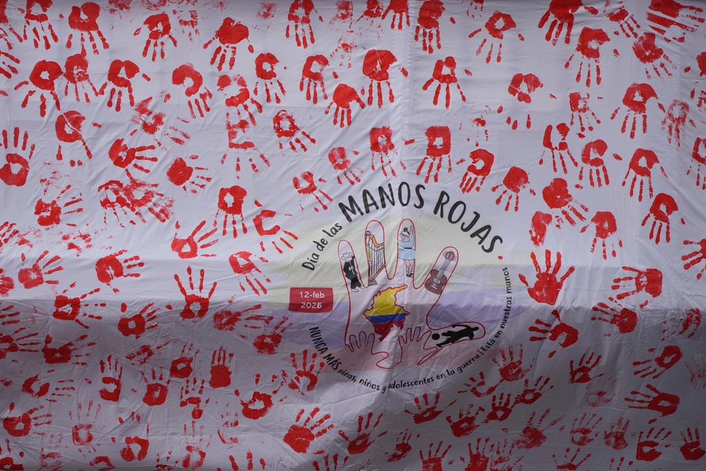 A sheet covered in handprints is displayed during an event marking Red Hand Day, also known as the International Day against the Use of Child Soldiers, in Bogota, Colombia, where illegal armed groups recruit children, Thursday, Feb. 12, 2026. (AP Photo/Fernando Vergara)