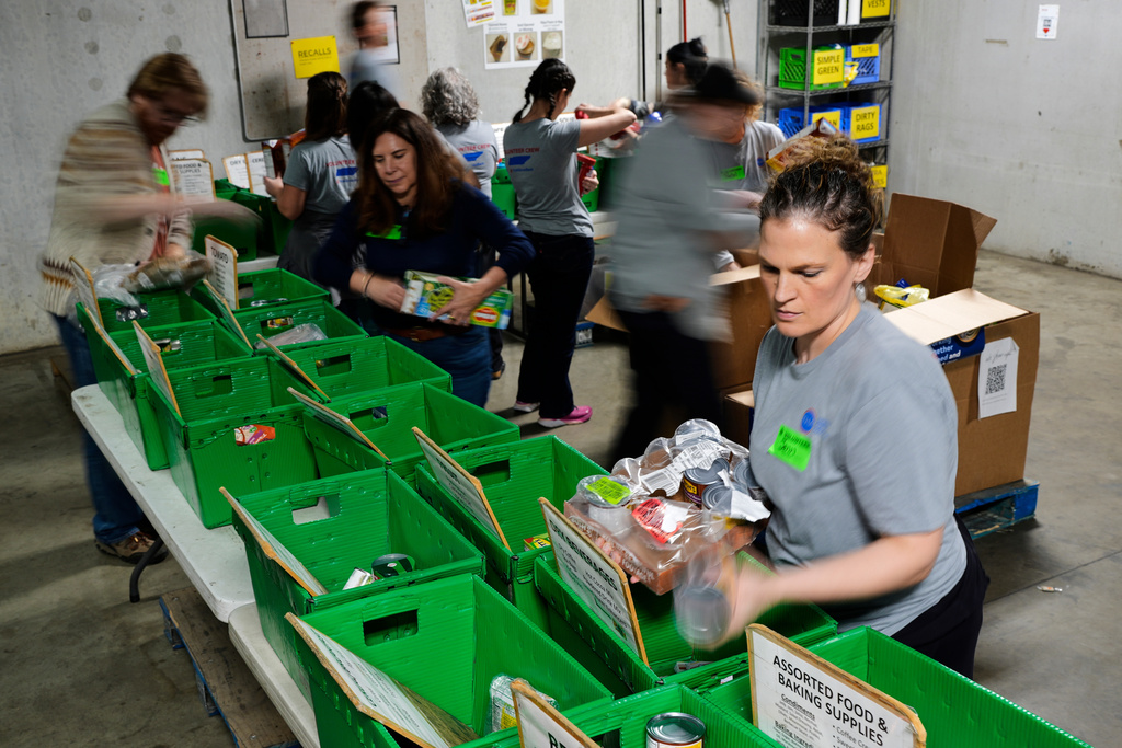 Jenn Hall, right, sorts food with other volunteers at Second Harvest Food Bank, Tuesday, Nov. 4, 2025, in Nashville, Tenn. (AP Photo/George Walker IV)