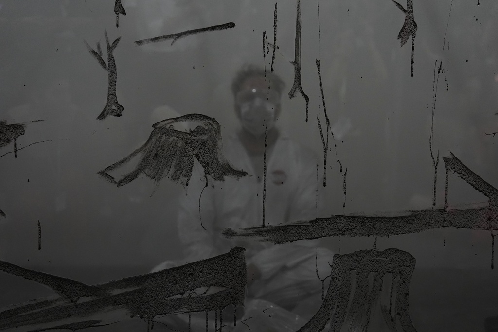 MUNDANO, a Brazilian artist, uses ashes collected from wildfires as he participates in a demonstration to raise awareness against forest destruction at the COP30 U.N. Climate Summit, Tuesday, Nov. 18, 2025, in Belem, Brazil. (AP Photo/Joshua A. Bickel)