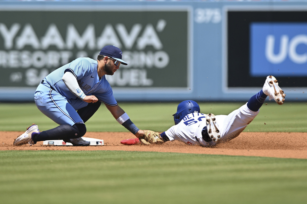 Los Angeles Dodgers' Mookie Betts, right, is tagged out by Toronto Blue Jays shortstop Bo Bichette, left, on a steal-attempt during the first inning of a baseball game Sunday, Aug. 10, 2025, in Los Angeles. (AP Photo/Wally Skalij)