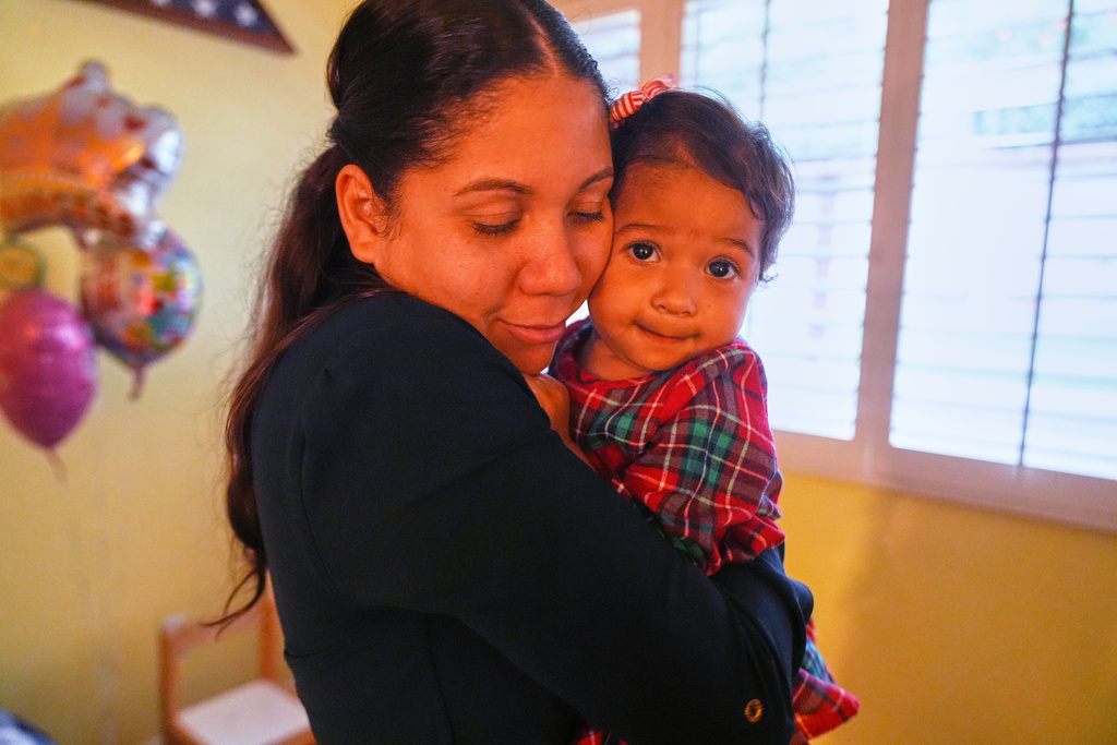 Kheilin Valero Marcano, hugs her 18-month-old daughter, Amalia Arrieta Valero, in Southern California on Tuesday, Feb. 10, 2026. (AP Photo/Damian Dovarganes)