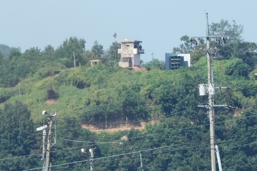 North Korean soldiers stand at a North Korean military guard post near a flying national flag, seen from Paju, South Korea, near the border with North Korea, Wednesday, Sept. 16, 2026. (AP Photo/Ahn Young-joon)