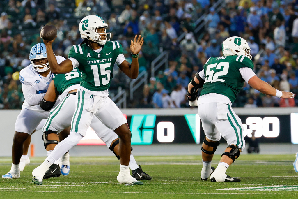 Charlotte quarterback Conner Harrell (15) looks to pass the ball over offensive lineman Jonny King (52) during the first half of an NCAA college football game against North Carolina in Charlotte, N.C., Saturday, Sept. 6, 2025. (AP Photo/Nell Redmond)
