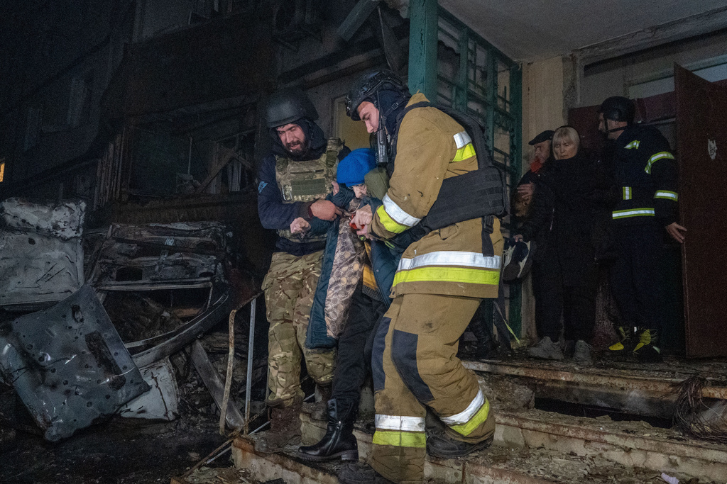 Rescuers evacuate an elderly woman after a residential building was hit following Russia's missile attack in Kharkiv, Ukraine Wednesday, Nov. 19, 2025. (AP Photo/Andrii Marienko)