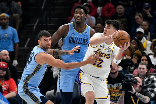 Los Angeles Lakers forward Jake LaRavia, right, handles the ball against Memphis Grizzlies guard John Konchar, left, and forward Jaren Jackson Jr., center, in the first half of an NBA Cup basketball game Friday, Oct. 31, 2025, in Memphis, Tenn. (AP Photo/Brandon Dill) Los Angeles Lakers forward Jake LaRavia, right, handles the ball against Memphis Grizzlies guard John Konchar, left, and forward Jaren Jackson Jr., center, in the first half of an NBA Cup basketball game Friday, Oct. 31, 2025, in Memphis, Tenn. (AP Photo/Brandon Dill)