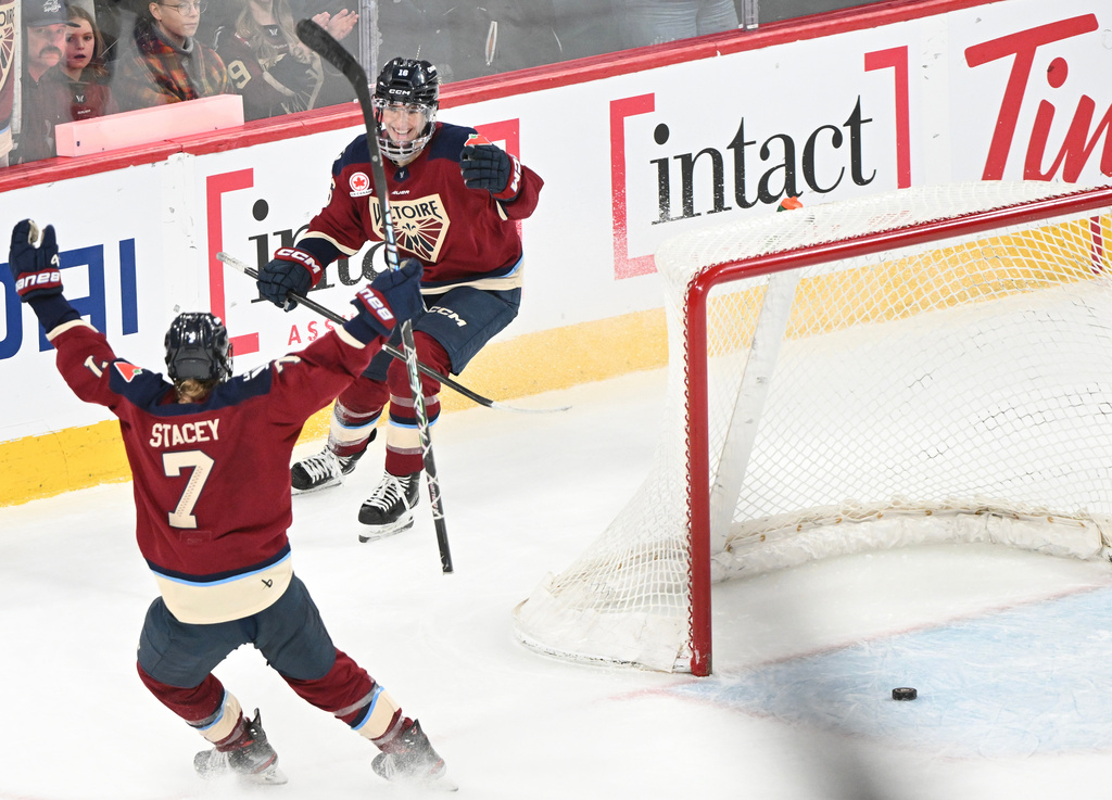 Montreal Victoire's Hayley Scamurra (16) celebrates with teammate Laura Stacey (7) after scoring an empty net goal against the Vancouver Goldeneyes during third period PWHL hockey action in Laval, Que., Wednesday, April 1, 2026. (Graham Hughes/The Canadian Press via AP)