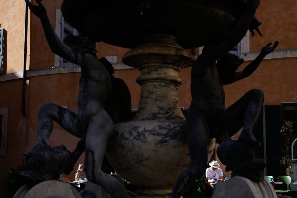 People sitting at a cafè are framed by the 1588 Fountain of the Turtles, by Giacomo Della Porta, in Rome, Thursday, April 16, 2026. (AP Photo/Gregorio Borgia)