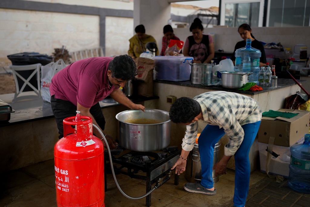 Farmhouse staff prepare food for stranded Indian travelers at a farmhouse owned by an Indian businessman, now converted into a shelter in Ajman, near Dubai, United Arab Emirates, Saturday, March 7, 2026. (AP Photo/Altaf Qadri)