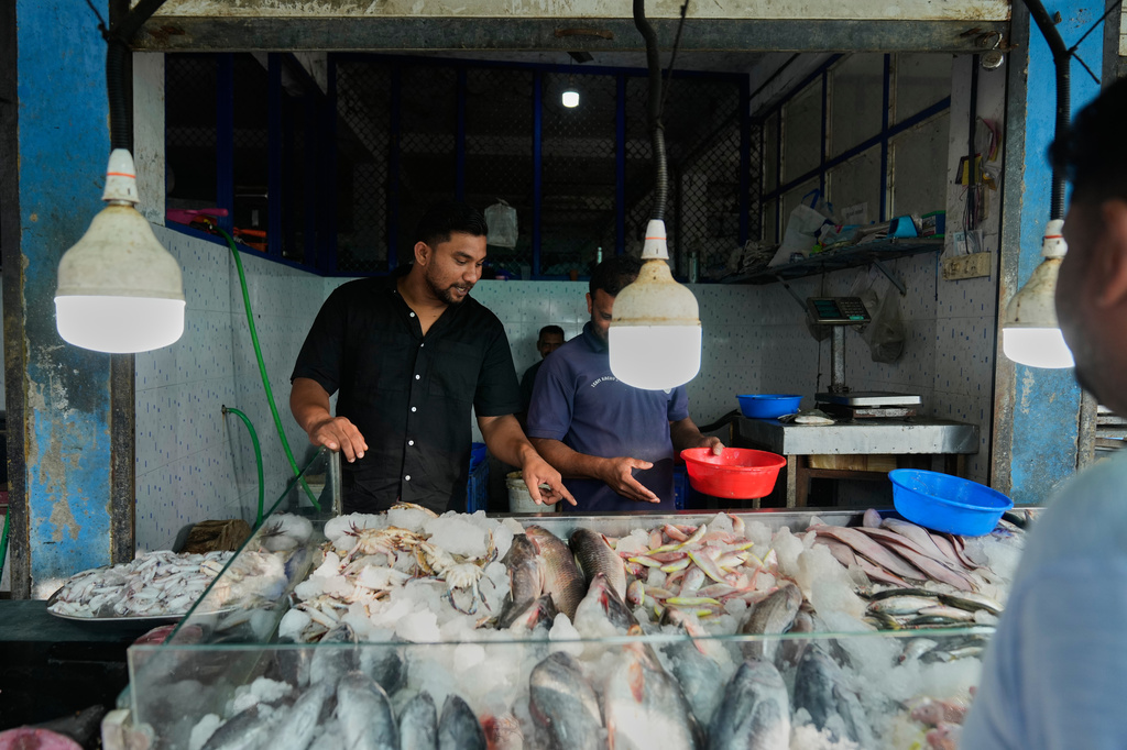 Safeer Mohammed Koorimannil walks through a wholesale fish market before opening his CM Fisheries office in Sulthan Bathery in the southern state of Kerala, India, Thursday, March 12, 2026. (AP Photo/Manish Swarup)