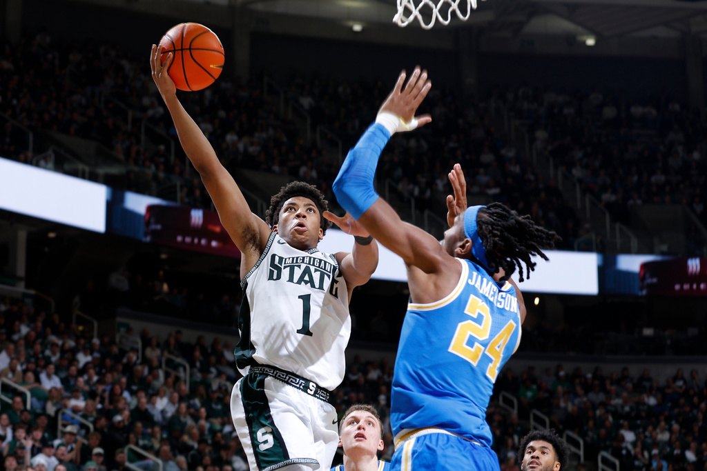 Michigan State guard Jeremy Fears Jr. (1), left, goes to the basket against UCLA center Steven Jamerson II (24) during the second half of an NCAA college basketball game, Tuesday, Feb. 17, 2026, in East Lansing, Mich. (AP Photo/Al Goldis)