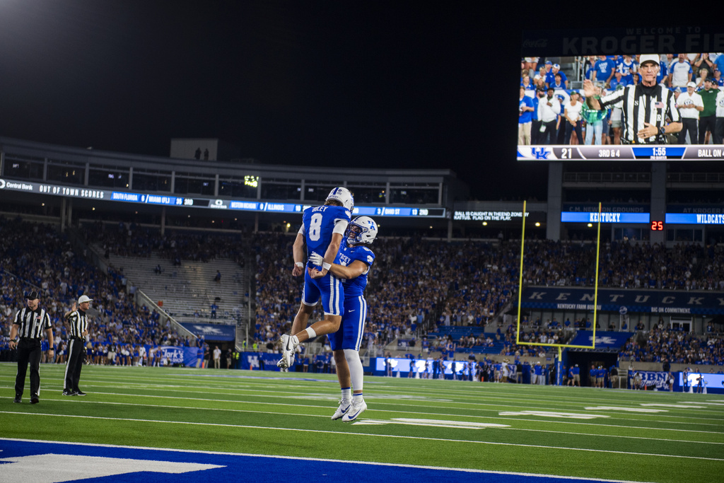 Kentucky quarterback Cutter Boley (8) and tight end Josh Kattus, center right, celebrate after scoring a touchdown in the second quarter of an NCAA college football game against Eastern Michigan, Saturday, Sept. 13, 2025, in Lexington, Ky. (AP Photo/Michael Swensen)