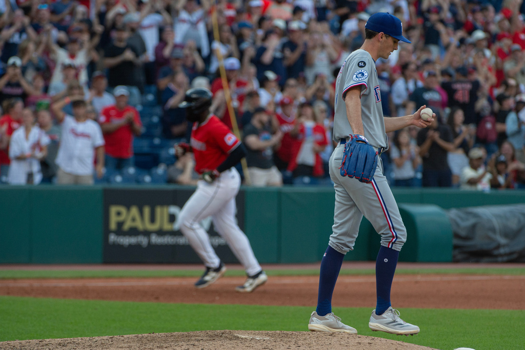 Texas Rangers relief pitcher Hoby Milner, right, walks from the mound as Cleveland Guardians' Jhonkensy Noel, back left, rounds the bases after hitting a solo home run during the seventh inning of a baseball game, Sunday, Sept. 28, 2025, in Cleveland. (AP Photo/Phil Long)