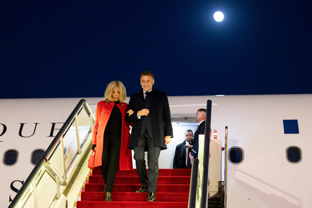 In this photo released by Xinhua News Agency, France's President Emmanuel Macron and his wife Brigitte Macron disembark from their plane upon arrival at the Beijing Capital International Airport, in Beijing, Wednesday, Dec. 3, 2025. (Cai Yang/Xinhua via AP)