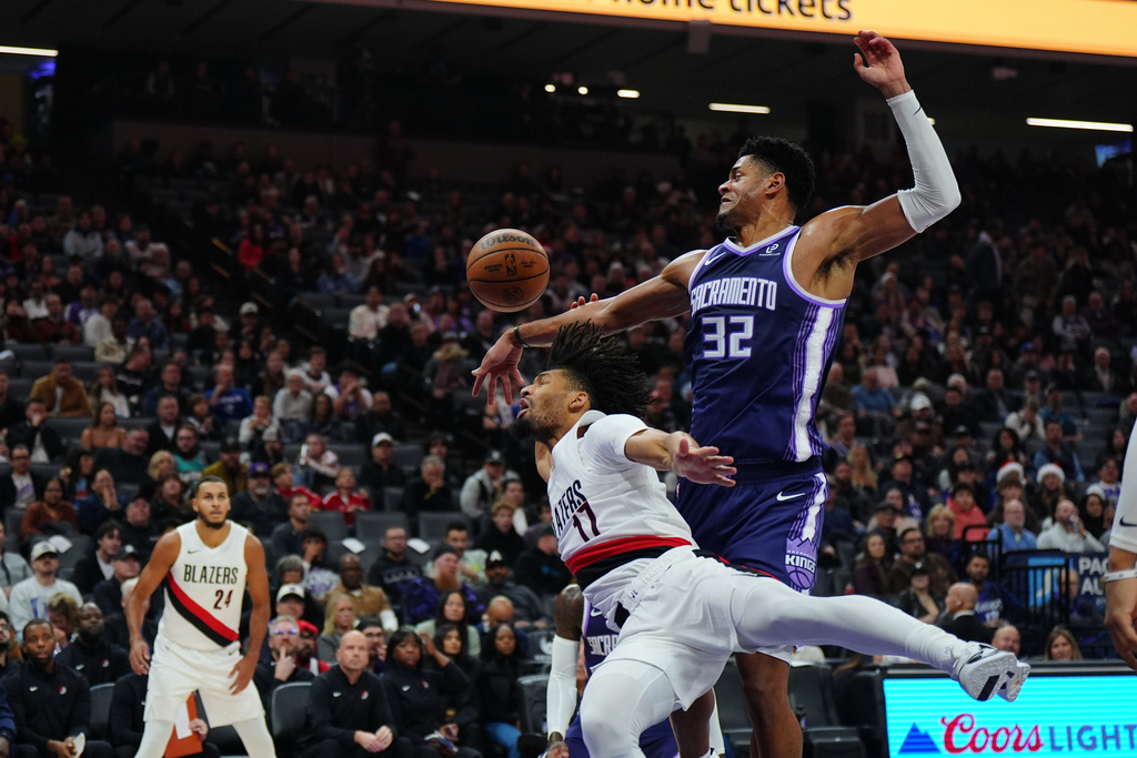 Sacramento Kings center Dylan Cardwell (32) and Portland Trail Blazers guard Shaedon Sharpe (17) fight for the ball during the first half of an NBA basketball game Saturday, Dec. 20, 2025, in Sacramento, Calif. (AP Photo/Alan Greth)