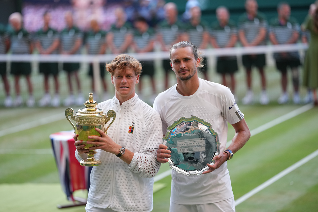 Champion Jannik Sinner of Italy and runner-up Alexander Zverev of Germany pose with their trophies after the men's singles final at Wimbledon Tennis Championships in London, Sunday, July 12, 2026. (AP Photo/Kirsty Wigglesworth)