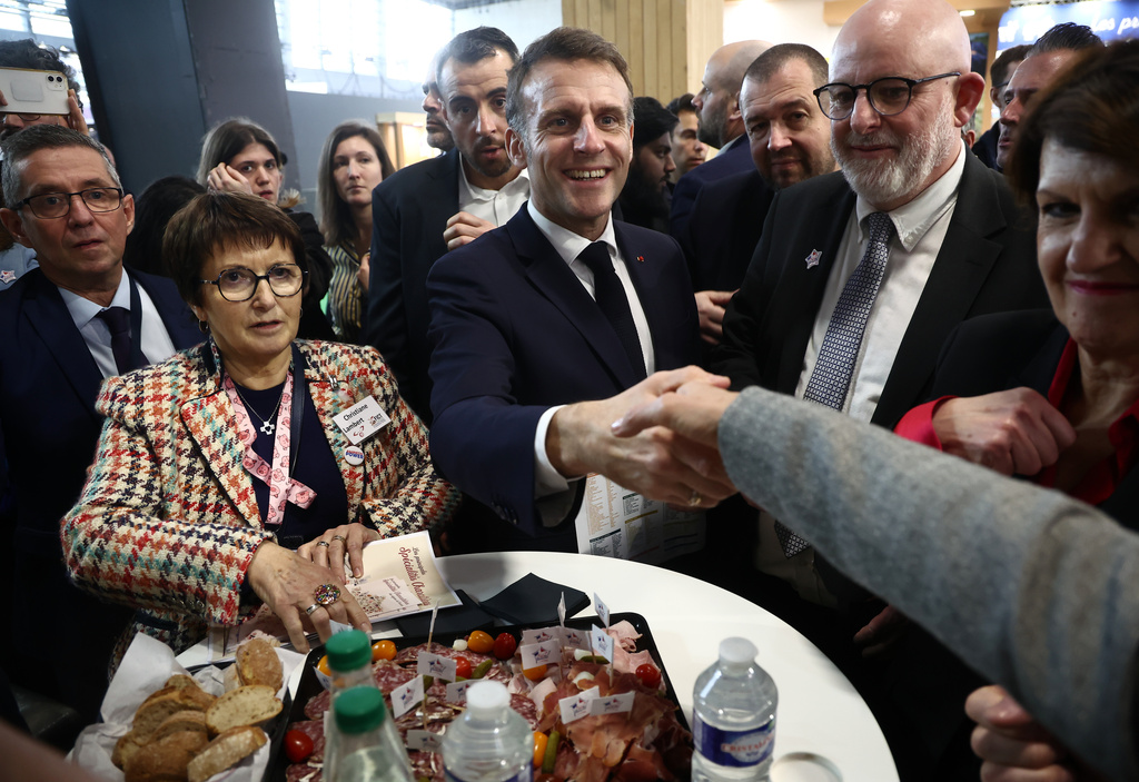 French President Emmanuel Macron, center, with Christiane Lambert, left, at the International Agriculture Fair during the opening day in Paris, Saturday, Feb. 21, 2026. (Christophe Petit Tesson/Pool Photo via AP)