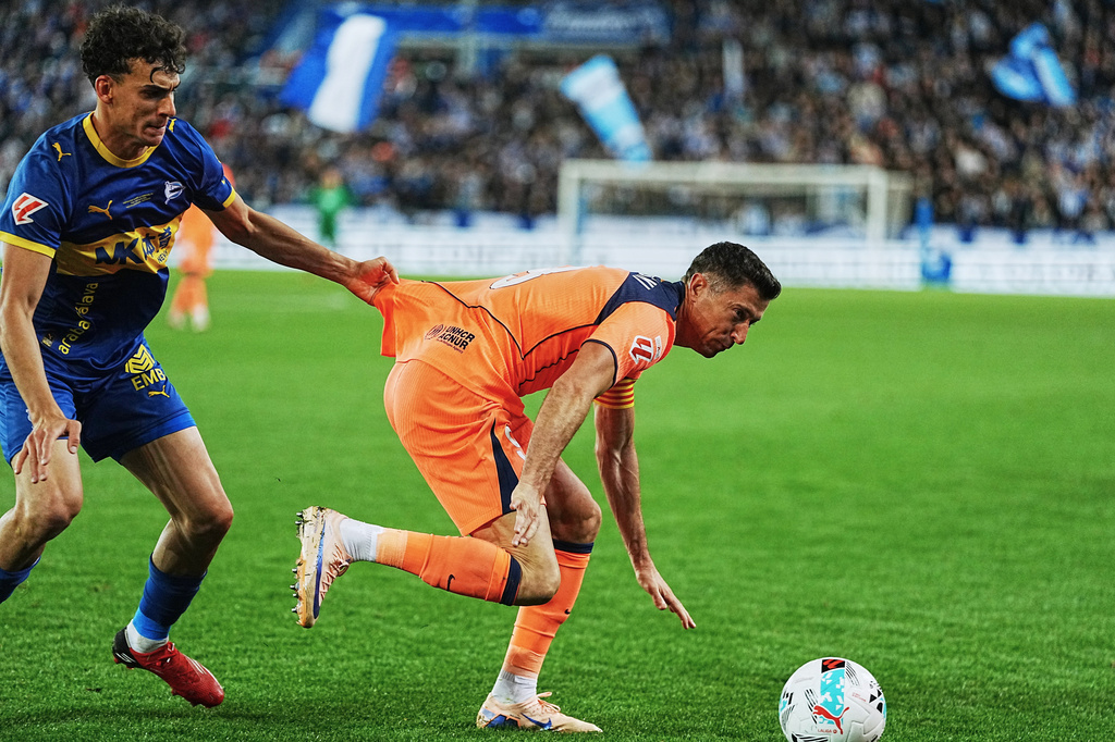 Barcelona's Robert Lewandowski, right, and Alaves' Angel Perez fight for the ball during the Spanish La Liga soccer match between Alaves and Barcelona in Vitoria-Gasteiz, Spain, Wednesday, May 13, 2026. (AP Photo/Miguel Oses)