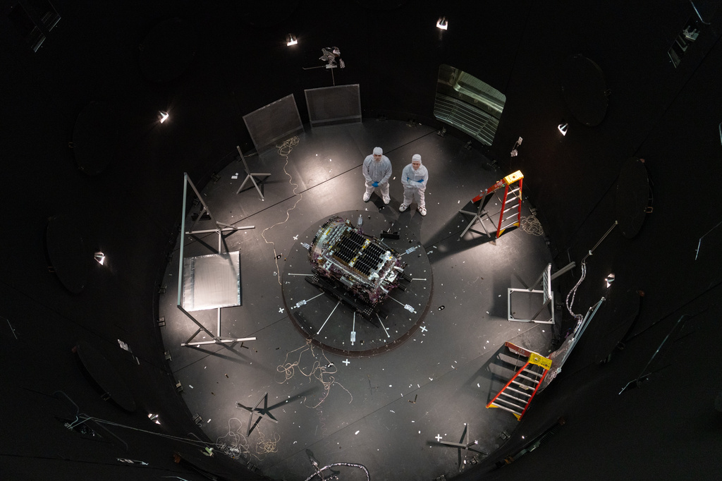 FILE - This photo provided by NASA shows Kieran Wilson, LINK's principal investigator, and Hunter Robertson, a space systems engineer, both at Katalyst Space, standing next to their spacecraft inside the SES (Space Environment Simulator) at NASA's Goddard Space Flight Center in Greenbelt, Md., April 17, 2026, ahead of thermal vacuum testing. (Sophia Roberts/NASA via AP, File)