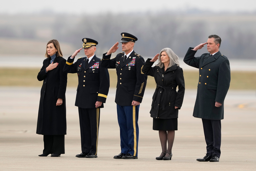 Iowa Gov. Kim Reynolds, from left, Major General Stephen E. Osborn, Adjutant General of the Iowa National Guard, Command Sgt. Maj. Matthew Strasser, Command Senior Enlisted Leader, U.S. Sen. Joni Ernst, R-Iowa, and U.S. Rep. Zach Nunn, R-Iowa, salute as the remains of Staff Sgt. Edgar Brian Torres-Tovar, 25, of Des Moines, and Staff Sgt. William Nathaniel Howard, 29, of Marshalltown, the two Iowa National Guard members killed in an attack in the Syrian desert, are moved during a dignified transfer at the Des Moines International Airport in Des Moines, Iowa, Wednesday, Dec. 24, 2025. (AP Photo/Charlie Neibergall)