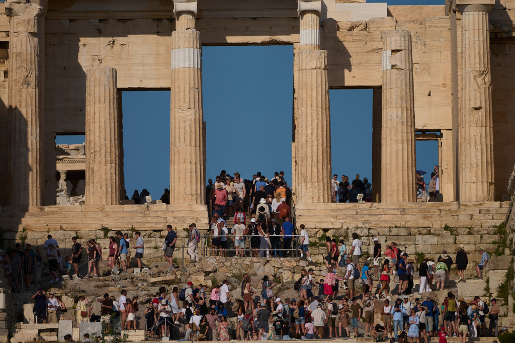 FILE - Tourists visit the 5th century BC Propylaea on the Acropolis Hill during a hot day in Athens, Greece, May 28, 2026.(AP Photo/Petros Giannakouris, File)