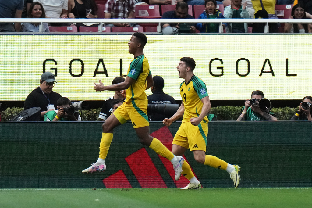 Jamaica's Bailey Cadamarteri, right, celebrates scoring his side's opening goal during a World Cup playoff semifinal soccer match between New Caledonia and Jamaica in Guadalajara, Mexico, Thursday, March 26, 2026. (AP Photo/Eduardo Verdugo)