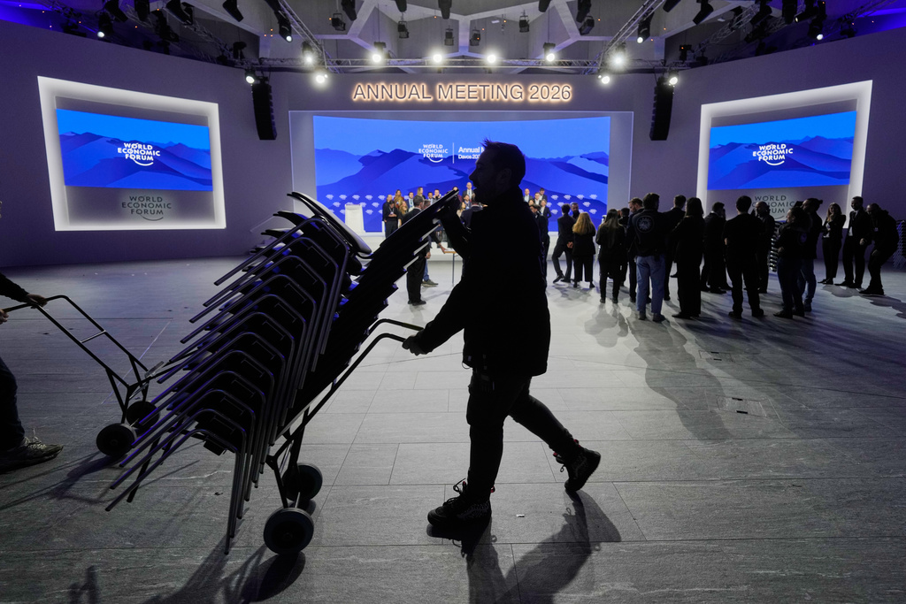 Workers remove chairs from the main hall on the final day of the Annual Meeting of the World Economic Forum, Switzerland, Friday, Jan. 23, 2026. (AP Photo/Markus Schreiber)