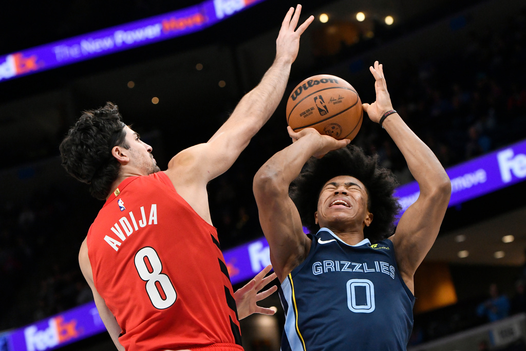 Memphis Grizzlies forward Jaylen Wells (0) shoots against Portland Trail Blazers forward Deni Avdija (8) in the first half of an NBA basketball game Sunday, Dec. 7, 2025, in Memphis, Tenn. (AP Photo/Brandon Dill)