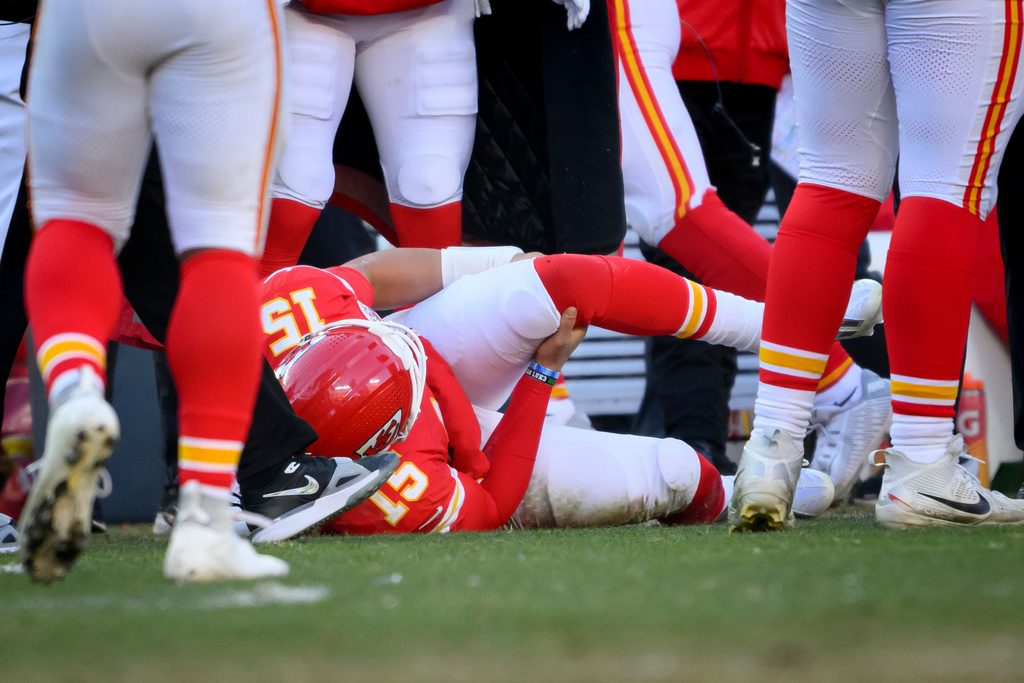 FILE - Kansas City Chiefs quarterback Patrick Mahomes (15) clutches his left knee after being injured during thine second half of an NFL football game against the Los Angeles Chargers, Sunday, Dec. 14, 2025 in Kansas City, Mo. (AP Photo/Reed Hoffmann, File)