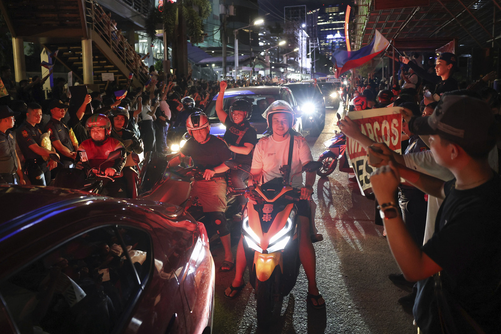 Motorists pass by protesters as they gather at the EDSA People Power Monument to rally against government corruption, in suburban Mandaluyong, east of Manila, Philippines, Sunday Sept. 21, 2025. (AP Photo/Basilio Sepe)