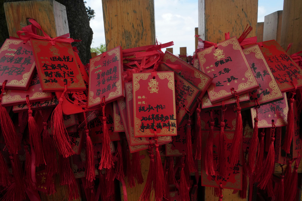 Red cards written with wishes are tied to a fence near the Golden Hall in Wudang Mountains in central China's Hubei Province on Sept. 3, 2026. (AP Photo/Achmad Ibrahim)