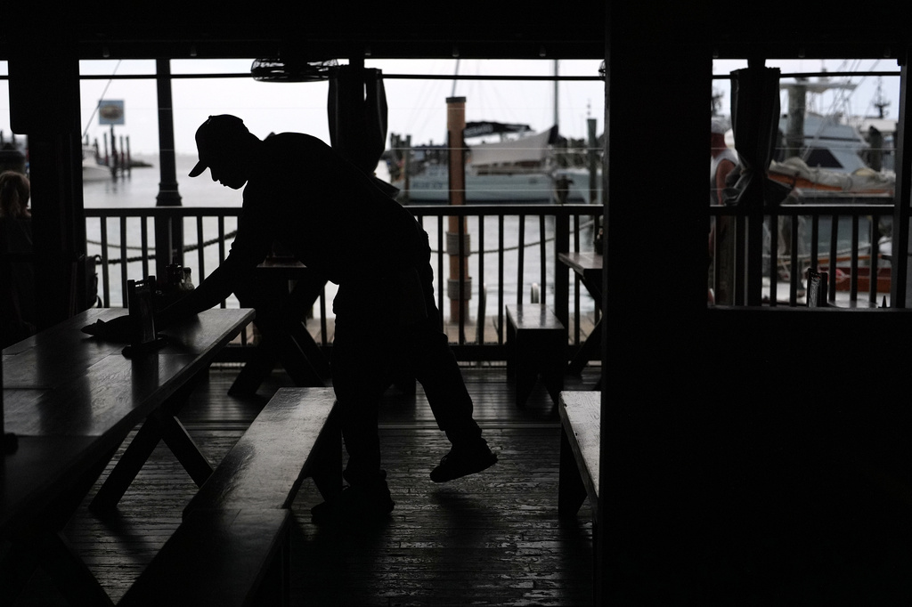 A Haitian worker with Temporary Protected Status cleans and busses tables at Half Shell Raw Bar, Friday, July 24, 2026, in Key West, Fla. (AP Photo/Rebecca Blackwell)