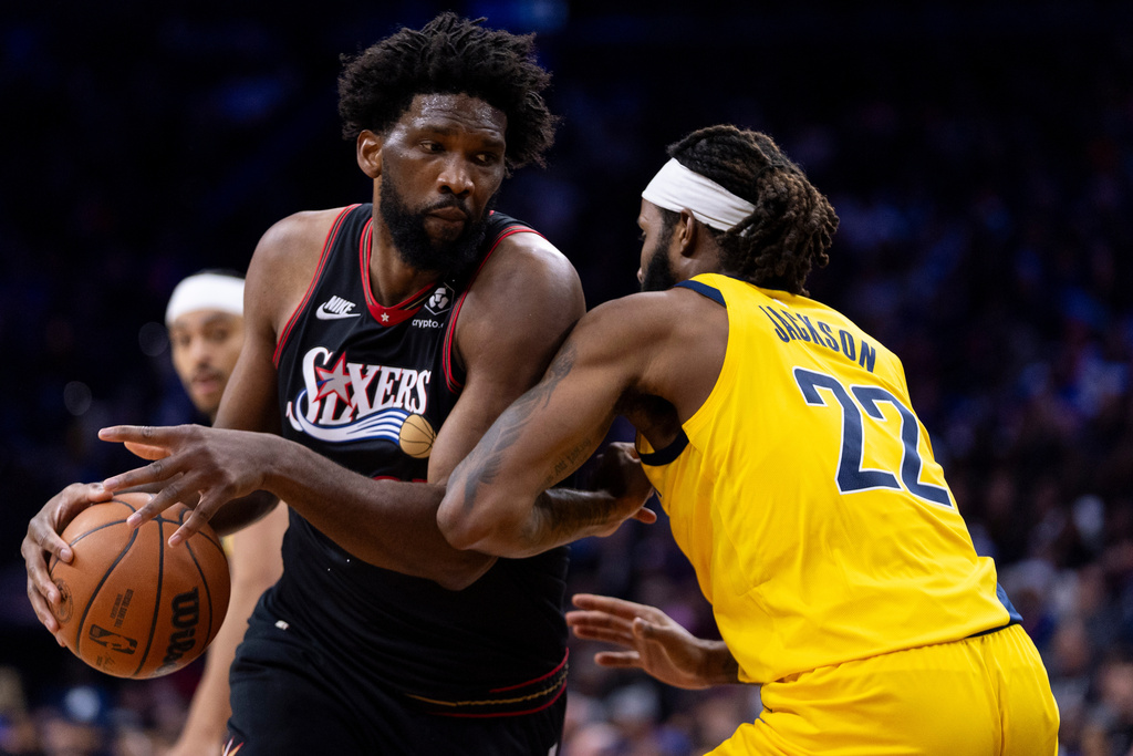Philadelphia 76ers' Joel Embiid, left, drives to the basket against Indiana Pacers' Isaiah Jackson, right, during the first half of an NBA basketball game, Friday, Dec. 12, 2025, in Philadelphia. (AP Photo/Chris Szagola)