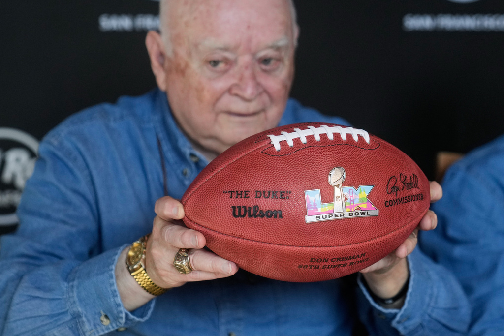 Don Crisman holds up a Super Bowl LX football presented to he and friends who have attended every Super Bowl football game by Wilson Sporting Goods, at a news conference at the Hard Rock Cafe in San Francisco, Friday, Feb. 6, 2026. (AP Photo/Jeff Chiu)