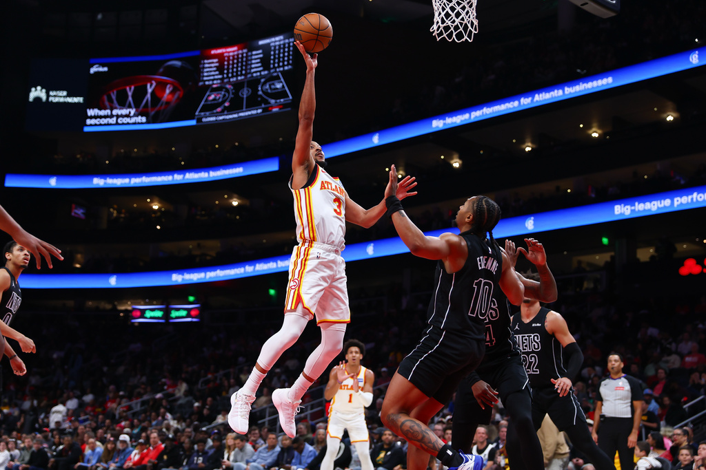 Atlanta Hawks guard CJ McCollum (3) shoots against Brooklyn Nets guard Tyson Etienne, right, during the first half of an NBA basketball game, Thursday, March 12, 2026, in Atlanta. (AP Photo/Colin Hubbard)