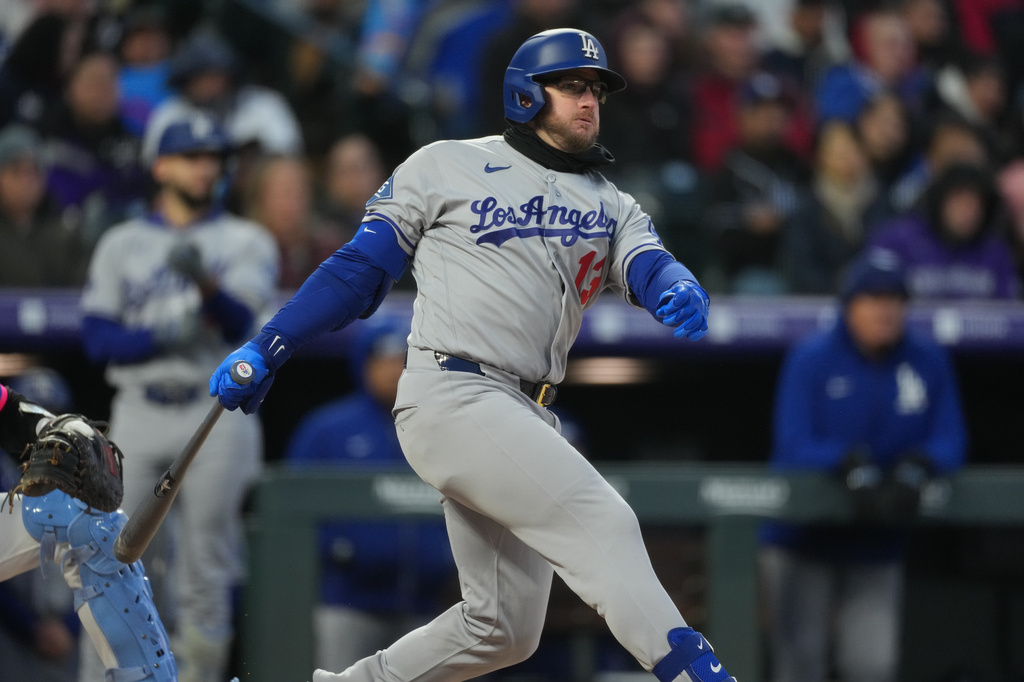 Los Angeles Dodgers' Max Muncy follows the flight of his RBI double off Colorado Rockies starting pitcher Tomoyuki Sugano in the third inning of a baseball game Friday, April 17, 2026, in Denver. (AP Photo/David Zalubowski)