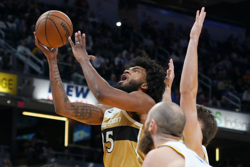 Washington Wizards forward Marvin Bagley III, left, shoots in front of Indiana Pacers center Jay Huff during the first half of an NBA basketball game in Indianapolis, Sunday, Dec. 14, 2025. (AP Photo/AJ Mast)