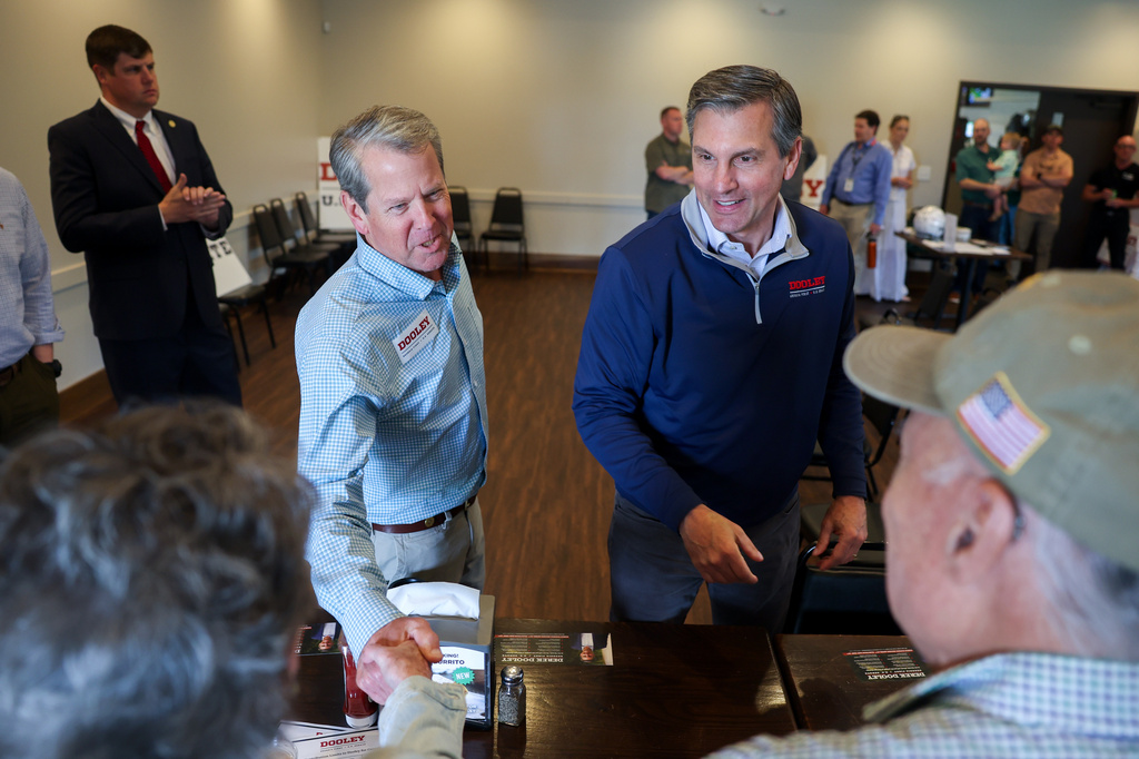 FILE - Gov. Brian Kemp, center left, and Republican U.S. Senate candidate Derek Dooley greet supporters at campaign stop for Dooley at Farmview Market in Madison, Ga., on May 8, 2026. (Arvin Temkar/Atlanta Journal-Constitution via AP, File)