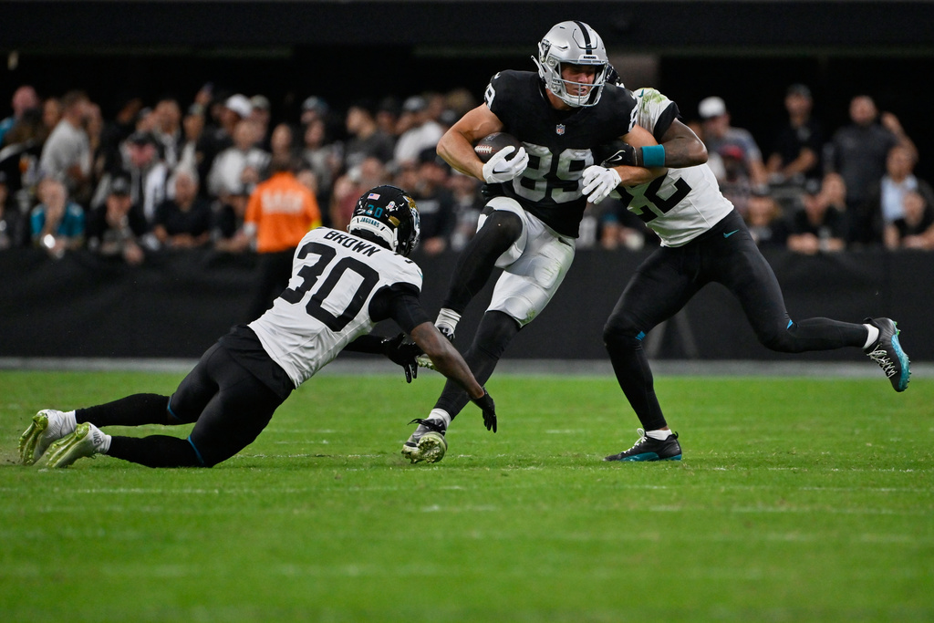 Las Vegas Raiders tight end Brock Bowers (89) is tackled by Jacksonville Jaguars cornerbacks Montaric Brown (30) and Jarrian Jones (22) during the second half of an NFL football game, Sunday, Nov. 2, 2025, in Las Vegas. (AP Photo/David Becker)