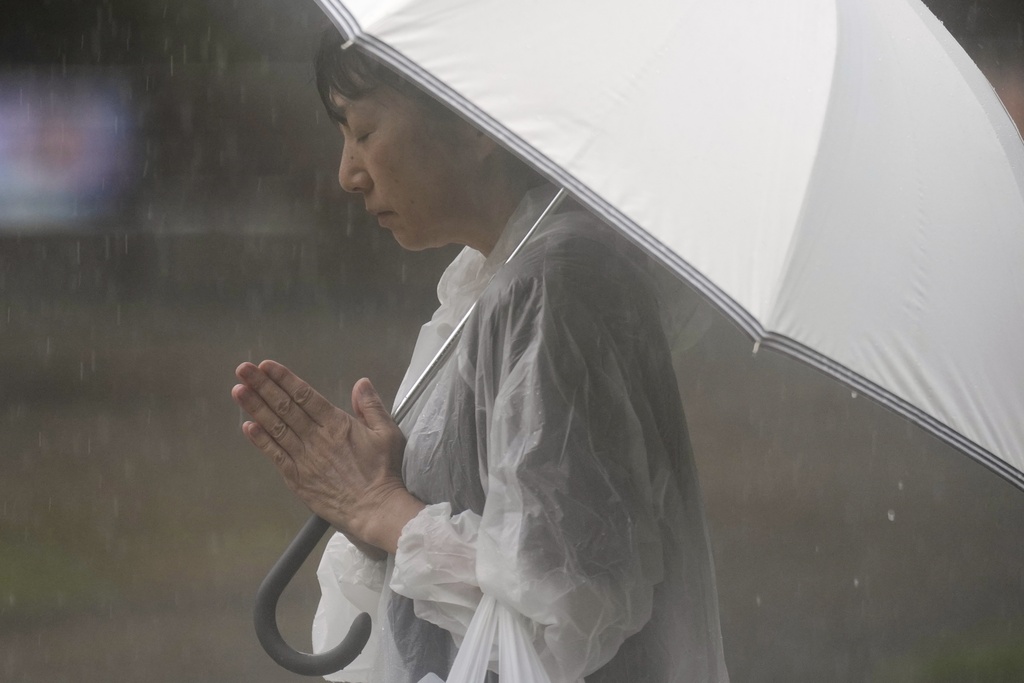 A person prays, ahead of a ceremony to mark the 80th anniversary of the WWII U.S. atomic bombing at Atomic Bomb Hypocenter Park in Nagasaki, western Japan Saturday, Aug. 9, 2025. (AP Photo/Eugene Hoshiko)