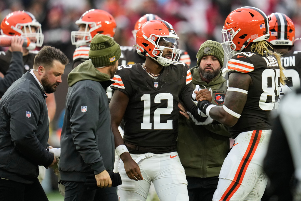 Cleveland Browns quarterback Shedeur Sanders (12) is helped off the field by tight end David Njoku (85) and trainers during the second half of an NFL football game against the San Francisco 49ers, Sunday, Nov. 30, 2025, in Cleveland. (AP Photo/Sue Ogrocki)
