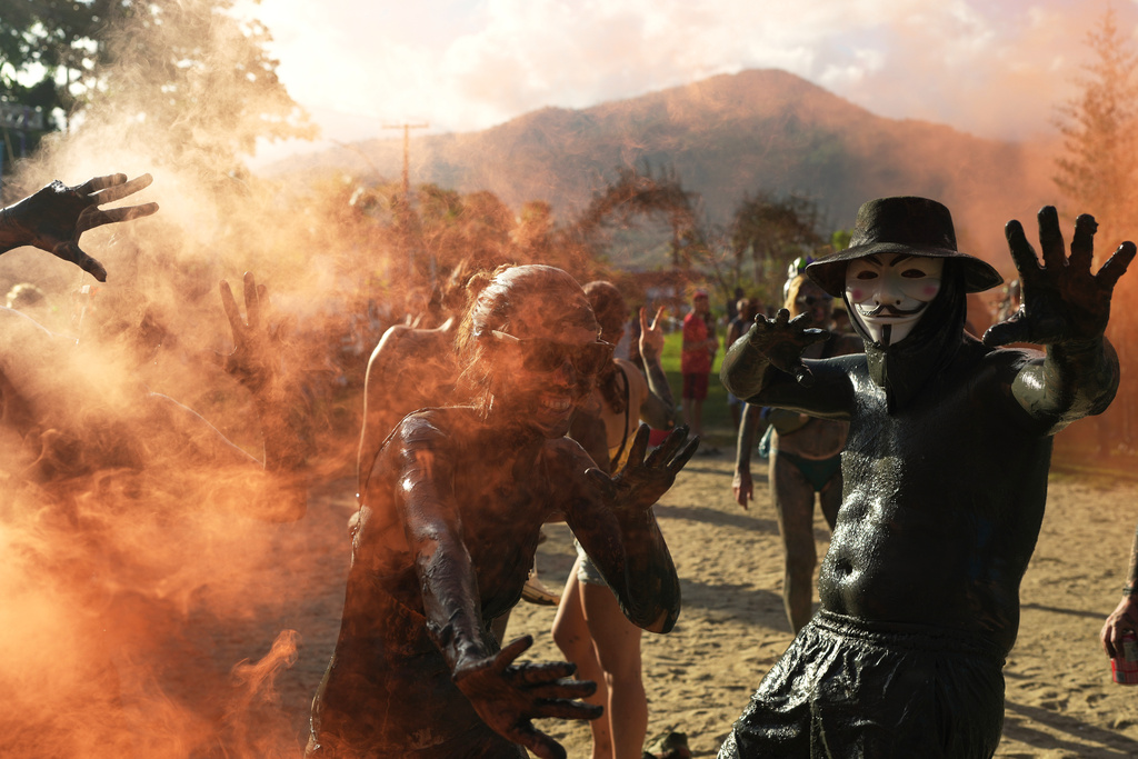 Revelers strikes poses during the Mud Block carnival party in Paraty, Brazil, Saturday, Feb. 14, 2026. (AP Photo/Andre Penner)