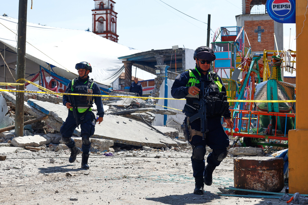 Mexico State police inspect the area destroyed by a fireworks explosion by the Santa María Canchesdá church in Temascalcingo, Mexico, Sunday, Sept. 6, 2026. (AP Photo/Ramses Mercado)